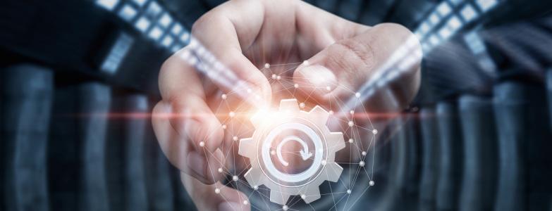 Ein futuristisches Bild mit einem Zahnrad abgebildet. Eine Hand dreht daran und das Zahnrad ist von Lichtern umgeben.